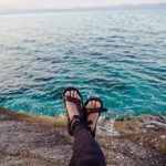 woman wearing hiking sandals near ocean