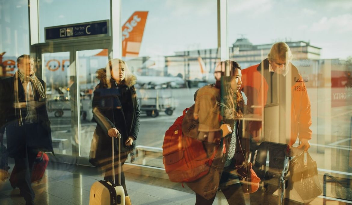 travelers with carry on in airport