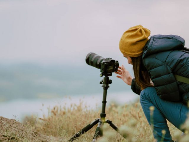 woman shooting with mirrorless camera at morning