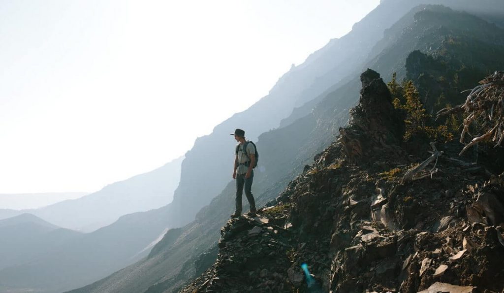 backpacker with hiking backpack in mountains