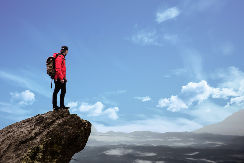 man hiking on mountains with small backpack
